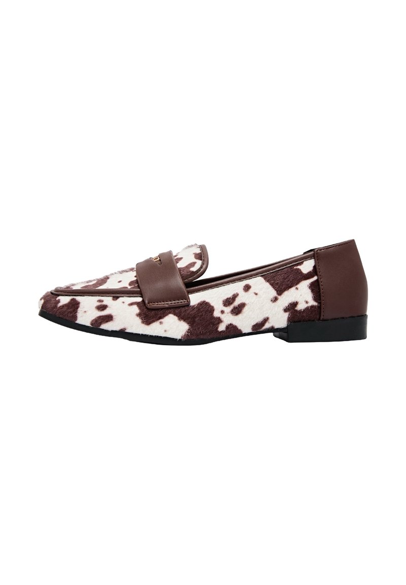 Mocassins en imprimé vache marron et blanc avec une sangle en cuir lisse et une semelle plate noire. Tige en tissu texturé avec un design à bout pointu.