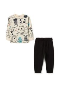 Kinderbekleidungsset mit einem langen cremefarbenen Oberteil mit Tierdruck und schwarzen Sweatpants mit einem elastischen Bund. Hergestellt aus weichem Baumwollmaterial.