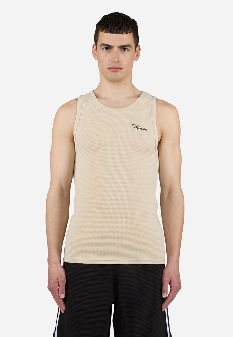 Beige ribbes tanktopp med rund halslinning og svart logo detalj på venstre bryst; kombinert med svarte teksturerte shorts. Glatt stoff.