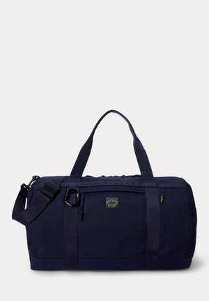 Geantă de voiaj bleumarin cu buzunar frontal cu fermoar, mânere duble pentru transport, curea de umăr reglabilă și patch cu logo Polo Country pe față.