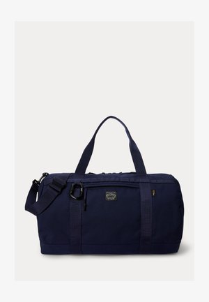 Laivastonsininen matkakassi, jossa etutasku vetoketjulla, kaksinkertaiset kantokahvat, säädettävä olkahihna ja Polo Country -logopatch etuosassa.