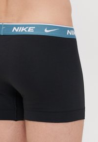 Fekete pamut boxeralsó világoskék gumis derékkal, fehér "Nike" logóval. Rövid szabású és sima tapintású.