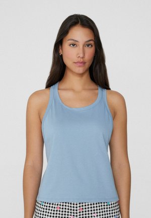 Canotta azzurro chiaro realizzata in tessuto morbido, con scollatura arrotondata e spalline sottili, abbinata a pantaloni shorts a righe bianchi e neri.