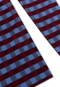 Rood en blauw geruit stof met een gestructureerde weving, met afwisselend vierkanten van effen kleuren en dunne strepen.