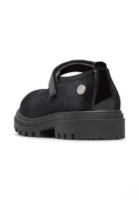 Chaussure en suede noire avec une bride en velcro et un détail de talon brillant. Dispose d'une semelle en caoutchouc texturé avec un motif à crampons pour une adhérence optimale.