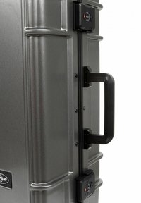 Valigia rigida grigia con finitura testurizzata, dotata di manico nero, meccanismo di chiusura e ruote multidirezionali.