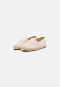 Scarpe espadrilles beige con suole in juta intrecciata, dotate di una tomaia in tela a fantasia e design con retro aperto.