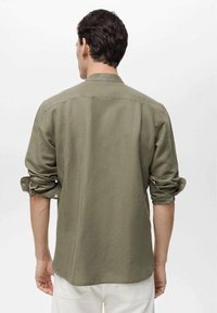 Grünes Langarmhemd aus leichtem Stoff, mit umgeschlagenen Manschetten und geradem Saum. Die Rückansicht zeigt ein schlichtes Kragendesign.
