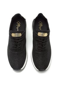 Schwarze Sportschuhe mit einer strukturierten Oberfläche, ausgestattet mit schwarzen Schnürsenkeln und einem goldenen Akzent auf der Zunge. Weiße Sohle mit abgerundeten Kanten.