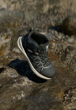 Tmavosivé vodotesné turistické topánky s sieťovanými panelmi, flexibilnou podrážkou a reflexnými šnúrkami. Majú vypchatý golier a značenie na boku.