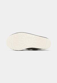 Σόλα παπουτσιού με λευκό καουτσούκ υλικό, υφασμένο σχέδιο και σκούρες πράσινες λεπτομέρειες, σχεδιασμένη για πρόσφυση και ανθεκτικότητα.