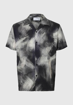 Kortärmad skjorta med knappar i svart och vitt med abstrakt penseldragsmönster, tillverkad av mjukt tyg, med klassisk krage och svarta knappar.