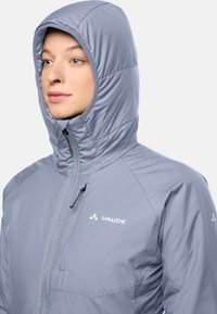 Lichtgrijze hooded jack met een gladde textuur, ritssluiting en branding op de borst. Beschikt over een aansluitende capuchon en een minimalistisch ontwerp.