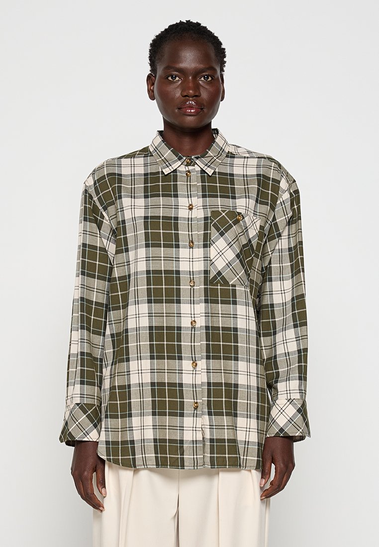 Camisa de cuadros verde y beige de manga larga, con cierre de botones y bolsillo en el pecho. Fabricada con tela tejida de textura suave.