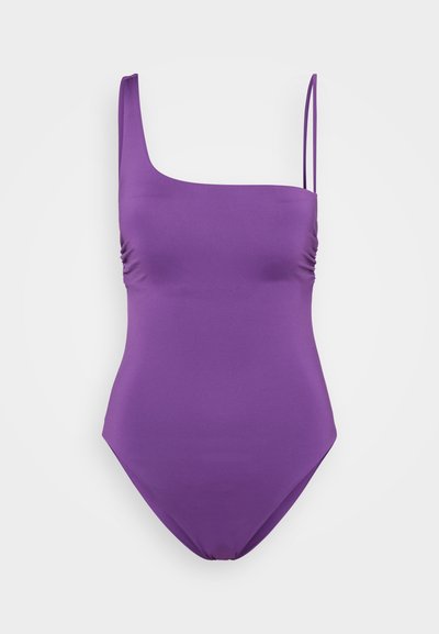 Bañador morado de un solo hombro con textura suave, detalle de fruncido en el lateral y tirante delgado ajustable. Sin patrones ni acentos.