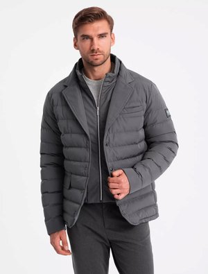 Chaqueta acolchada gris con un diseño de doble botonadura, textura acolchada y cuello. Presenta bolsillos laterales y una silueta ajustada.