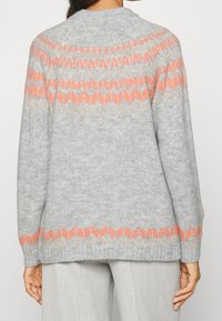 Szary sweter z dzianiny z okrągłym dekoltem, długimi rękawami i geometrycznym wzorem w kolorze koralowym i złotym na górnej części pleców.