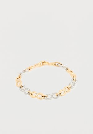 Goud- en zilverkleurige schakelhalskettingarmband met afwisselend gladde schakels en met strass bezette gebogen schakels, plat neergelegd op een witte achtergrond.