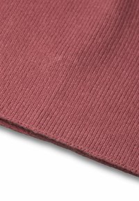 Tessuto a coste in rosa polveroso, con una superficie morbida e rifiniture dei bordi. Il materiale sembra essere a maglia con strisce verticali.