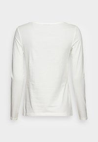 Witte lange mouwen t-shirt gemaakt van zachte katoen. Heeft een ronde halslijn en een slim-fit ontwerp zonder patronen of extra details.