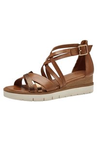 Brown leather wedge sandal with cross straps, featuring a textured metallic accent and a white platform sole. Adjustable buckle closure.