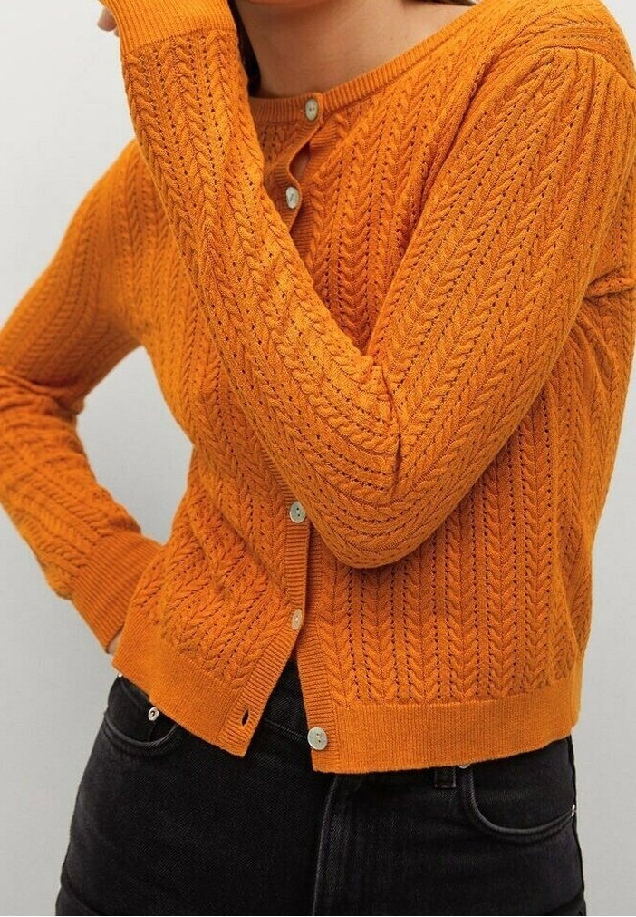 Cardigan orange tricoté avec un motif texturé, manches longues et encolure ronde. Comprend une fermeture à boutons et un ourlet côtelé.