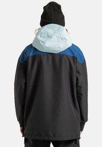 Czarna wodoodporna kurtka z jasnoniebieskimi i granatowymi akcentami, z kapturem i luźnym krojem. Gładka tekstura i długie rękawy.
