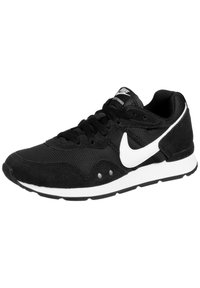 Black athletic shoe with mesh and suede materials. Features white Nike swoosh, textured surface, padded collar, and black laces.