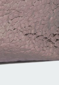 Materiał o fakturze w jasnym fioletowym kolorze, z pękającym wzorem powierzchni, tworzący unikalny wygląd z lekko błyszczącym wykończeniem.