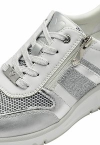 Sneaker bianco con dettagli argentati e inserti in rete. Presenta lacci, una chiusura con zip e una striscia argentata testurizzata sul lato.