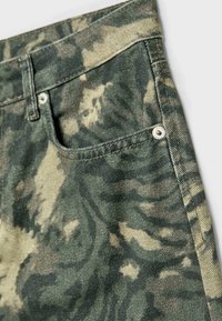 Jeans con motivo camouflage in diverse tonalità di verde e tan, realizzati in denim. Comprendono una tasca frontale e dettagli con bottoni in metallo.