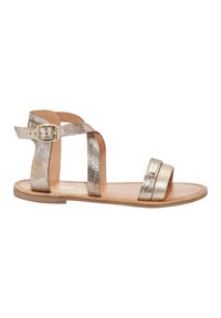 Gouden sandalen met meerdere textuurbanden, een gespsluiting en een platte zool. Beschikt over een gladleren binnenzool en minimaal detail.