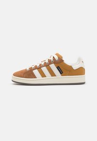 Sneaker in suede e tela marrone con strisce bianche, punta tondeggiante e suola beige. Presenta lacci classici e etichetta nera "CAMPUS".
