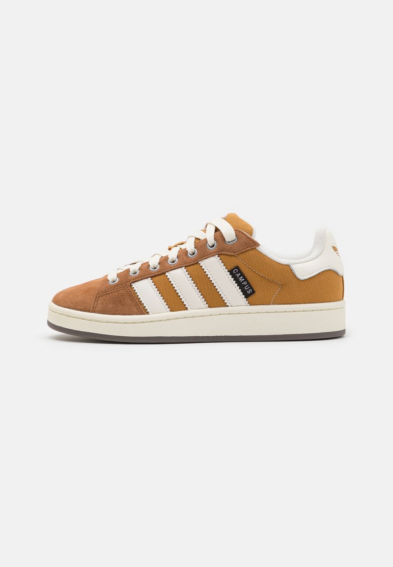 Sneaker in suede e tela marrone con strisce bianche, punta tondeggiante e suola beige. Presenta lacci classici e etichetta nera "CAMPUS".