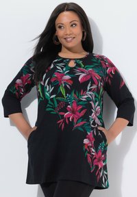 Czarna tunika z żywym, kwiatowym haftem w odcieniach różu, czerwieni i zieleni. Dekolt z wycięciem typu keyhole oraz rękawy o długości do łokcia. Wyposażona w boczne kieszenie.