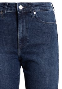 Donkerblauwe denim jeans met een klassiek ontwerp, voorzien van een rits, knoopsluiting en voorzakken. Glad textuur met subtiele stikseldetails.