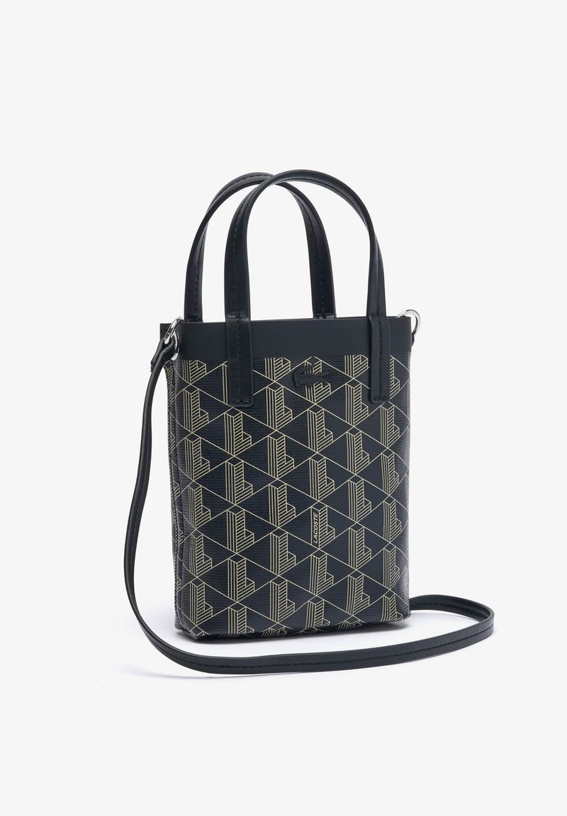 Sac à main noir à motifs géométriques avec double anses courtes et une bandoulière ajustable. Présente une forme structurée et un matériau texturé.