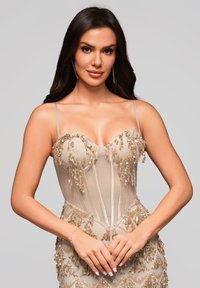 Beiges Korsettkleid aus transparentem Stoff, mit Perlenverzierungen und einer figurbetonten Silhouette. Es verfügt über dünne, verstellbare Träger und aufwendige Details.