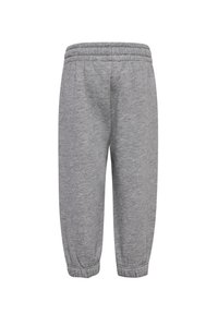 Grå svettbyxor i mjukt tyg, med elastisk midja, avsmalnande anklar och en texturerad yta utan synliga sömmar.