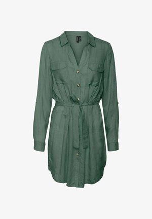 Zöld, hosszú ujjú ruha sima anyagból. Galléros nyakkal, gombos előlappal, két mellzsebbel és megkötős derékkal rendelkezik.