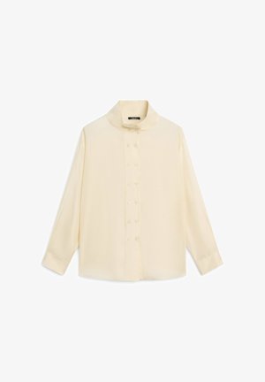 Blusa a manica lunga color crema con colletto alto e doppia fila di bottoni sul davanti, distesa su uno sfondo bianco.