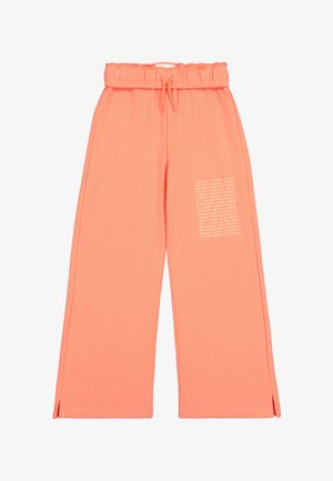 Różowe dresy z szerokimi nogawkami, elastycznym paskiem i sznurkiem do ściągania. Posiadają biały nadrukowany detal z tekstem po lewej stronie. Materiał z domieszką bawełny.