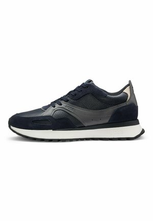 Navyblauwe sneakers met een mix van textuurleer en suède, met een grijze accent en een witte tussenzool. Inclusief veters en discrete branding.