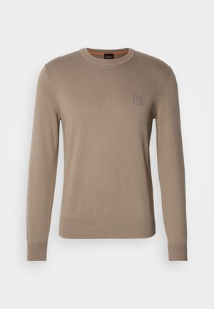 Men’s beige crewneck sweater with long sleeves, ribbed cuffs and hem, featuring a small square logo patch on the chest.