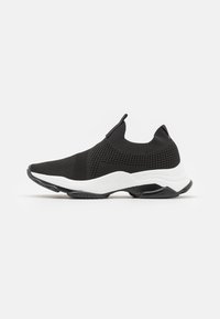 Fekete hálós sportcipő, slip-on kialakítással, fehér középtalppal, mely texturált díszítéssel rendelkezik, és gumitalppal a tapadás érdekében.