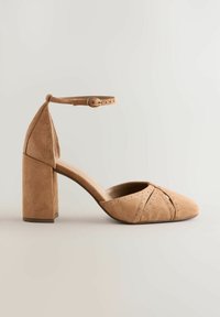Beiger Veloursleder-Pumps mit spitz zulaufender Spitze, Knöchelriemen und Blockabsatz. Verfügt über perforierte Details und ein glattes Innenfutter.
