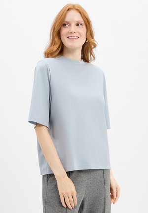 Helles blaues T-Shirt mit kurzen Ärmeln und hohem Kragen. Hergestellt aus weichem Stoff, bietet es eine lockere Passform und ein sauberes, minimalistisches Design.