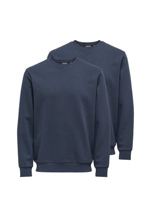 Twee effen marineblauwe crewneck-sweaters met lange mouwen en geribbelde boorden en zoom, overlappend weergegeven op een witte achtergrond.