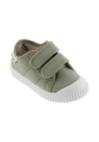 Baskets en toile vert clair avec deux bandes Velcro, capuchon en caoutchouc blanc et semelle texturée avec des ridges pour l'adhérence.