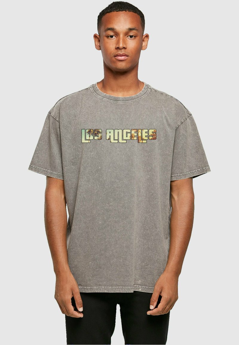 Oversized grijze T-shirt van gewassen denim stof, met de tekst "LOS ANGELES" in multicolore letters over de borst.